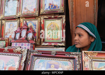 L'Inde, Uttar Pradesh, Ayodhya, Femme vendant des images de dieux hindous et les déités dans le marché. Banque D'Images