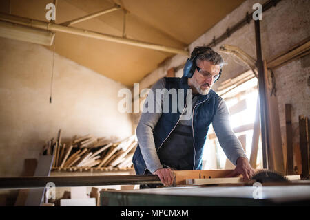 Un homme travailleur dans l'atelier de menuiserie, travail du bois. Banque D'Images