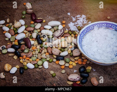 Les haricots colorés sur une surface en bois avec des cristaux de sel. Isolées. Le point de droit. Banque D'Images