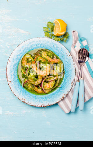 La cuisine mexicaine. Aguachile de camaron. Gambas aguachile. Eviche cebiche avec crevettes concombre, citron et oignon violet. Vue d'en haut, sur fond bleu. Banque D'Images