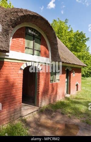 Grange en brique rouge au Musée de Folklore : une grange de chaume en brique rouge se trouve dans un luxuriant grass prairie au Lyngby Folk Museum. Banque D'Images