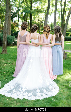 Célébration, de l'engagement, l'amitié femme concept. dos de quatre jeunes femmes slim, happy bride in traditionnellement robe blanche et ses amis, de l'article ba Banque D'Images