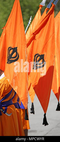 Grand drapeau orange avec symbole de Khanda Sikh appelé durant une cérémonie religieuse Banque D'Images
