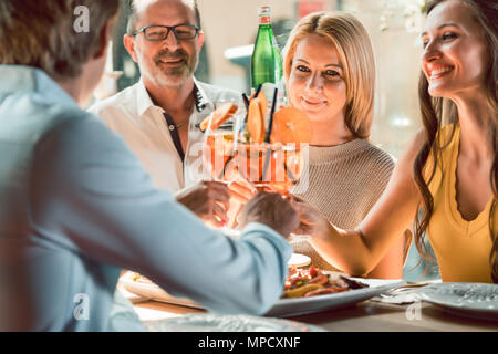 Young Friends toasting with cocktails avant de manger dans un restaurant de fruits de mer Banque D'Images