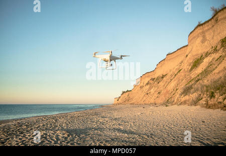 Drone survolant déserté conte de plage au sable doré et le bleu de l'eau sur les rives de l'océan. Endroit romantique près de la mer. Jour nuageux. Banque D'Images