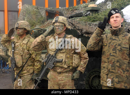 La CPS. Nicolas Kotsonis(au milieu) et la CPS. Erinne Bowyer(gauche), tous deux assignés à 588th bataillon du génie de la Brigade Blindée, 3e Brigade Combat Team, 4e Division d'infanterie et le Cpl. Peter Knyszek, affecté à la 23e Régiment d'artillerie, rendre salue durant une cérémonie de célébration pour accueillir les troupes américaines à Wrocław, Pologne, le 5 février 2017. La célébration a été l'occasion pour les citoyens polonais d'accueillir les soldats du 588th BEB, qui passeront les prochains mois. L'arrivée de l'ABCT 3-4 marque le début des rotations de brigades blindées en Europe dans le cadre de l'Atlant Banque D'Images