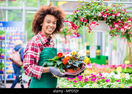 Portrait d'une jeune femme travaillant comme fleuriste dans un magasin de fleur Banque D'Images