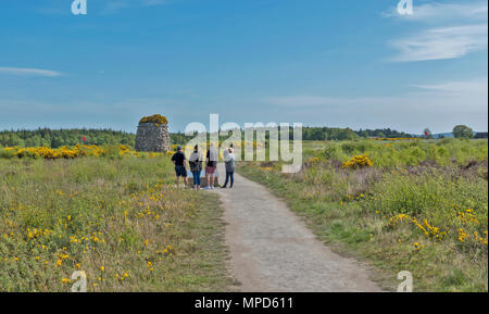 Ou de la bataille de Culloden Moor INVERNESS ECOSSE LE Cairn commémoratif entouré d'ajonc JAUNE ET UN GROUPE DE VISITEURS LA LECTURE DES PANNEAUX D'INFORMATION Banque D'Images