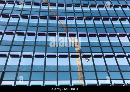 Grue de construction reflète dans un nouveau bâtiment de windows, Boirmingham UK Banque D'Images