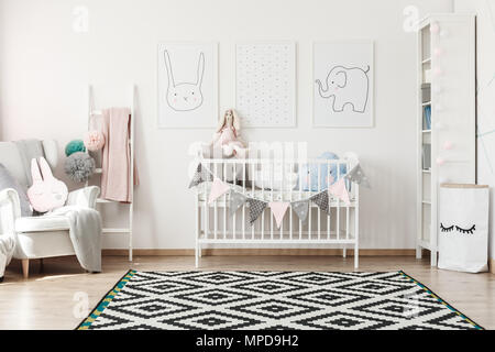 Tapis géométriques en scandi chambre d'enfant avec lit blanc, fauteuil gris et sac de papier pour les jouets Banque D'Images