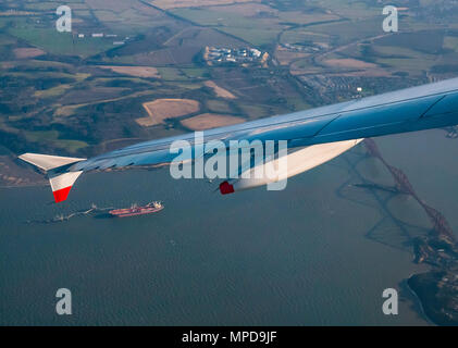 British Airways Airbus 319 incliné vers l'aile d'avion vu de la fenêtre de l'avion après le décollage de l'aéroport d'Édimbourg au-dessus de Forth Rail Bridge avec pétrolier Banque D'Images