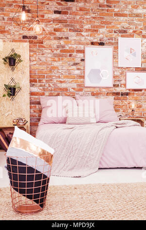 Chambre avec lit double et mur de brique rouge Banque D'Images
