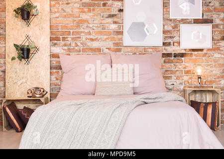 Chambre en mezzanine avec lit double et literie rose poussiéreux Banque D'Images
