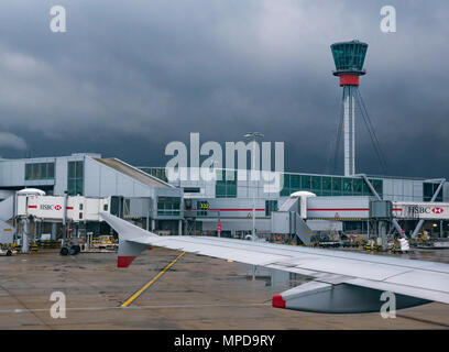 De voir le ciel des ponts, Terminal 5, Heathrow Airport, Londres, Angleterre, Royaume-Uni, prises à partir de la fenêtre de l'avion, avec l'aile d'avion et tour de contrôle visible. Banque D'Images