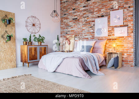 Chambre à coucher avec lit double, mur de briques et de tapis Banque D'Images