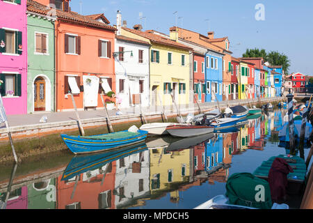 Les cabanes de pêcheurs aux couleurs vives reflètent dans un canal, Burano, Venise, Italie au début de la lumière du matin. L'île est une attraction touristique populaire Banque D'Images