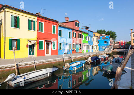 Les cabanes de pêcheurs aux couleurs vives reflètent dans un canal, Burano, Venise, Italie au début de la lumière du matin. L'île est une attraction touristique populaire Banque D'Images