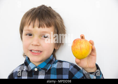 Portrait de cinq ans en chemise à carreaux bleu holding apple and smiling on white background Banque D'Images