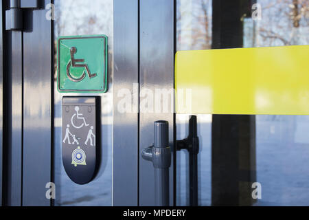 Appel sur porte avant en verre du bâtiment et la plaque avec l'image des personnes handicapées personne en fauteuil roulant et les personnes avec bâton de marche Banque D'Images