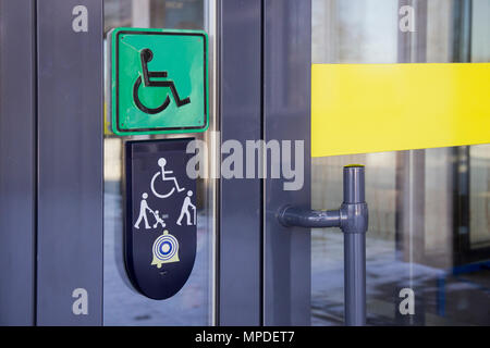 Appel sur porte avant en verre du bâtiment et la plaque avec l'image des personnes handicapées personne en fauteuil roulant et les personnes avec bâton de marche Banque D'Images