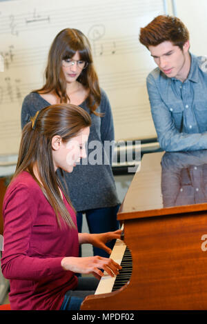 Pianiste avec les élèves de sexe féminin Banque D'Images