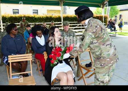 Lauren R. Tudor épouse de nouveau commandant Le Capitaine Wesley Tudor, reçoit un bouquet de roses rouges d'un soldat au cours de la cérémonie de passation de commandement pour 106e Unité de soutien de la gestion financière, 16e Brigade de soutien à Caserma Ederle à Vicenza, Italie, 10 avril 2017. Banque D'Images