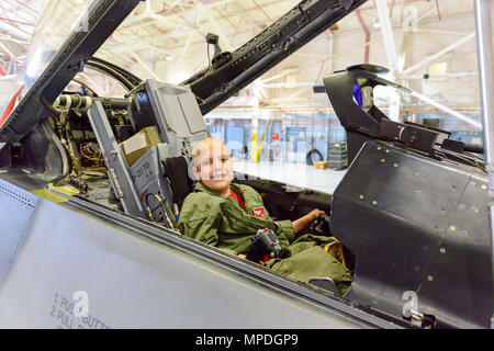 Sam "brûleur" Bilby, 138e Escadre de chasse, pilote d'un jour, se trouve dans et apprend sur un poste de pilotage des chasseurs F-16 au cours d'une visite personnalisée qui a eu lieu ici le 10 avril 2017. Le pilote d'un jour est un programme permettant aux enfants atteints de maladies menaçant la vie potentiellement une chance de vivre une journée dans la vie d'un pilote de chasse F-16. Banque D'Images