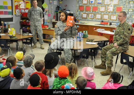 Le sergent 1ère classe Arianna Joe, centre, un assistant de l'aumônier avec le 88e Commandement du soutien régional, présente le Dr Seuss' Green Eggs and Ham avant de le lire à un groupe d'élèves de maternelle de l'école élémentaire Lawrence-Lawson à Sparte, dans le Wisconsin, dans le cadre de lire ensemble le jour de l'Amérique le 2 mars. Le s.. Nicholas Gimson, à gauche, et Sgt. Robert Clark, tant avec le 88e Commandement du soutien régional, lisez également à d'autres élèves de l'école élémentaire. Banque D'Images