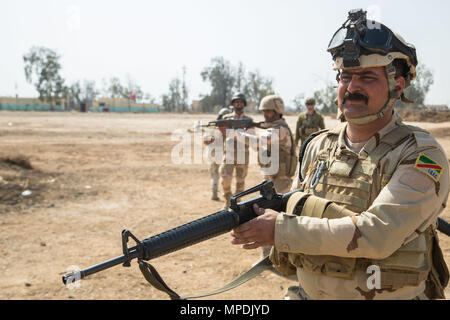 Un soldat des forces de sécurité irakiennes d'analyses pour réagir à une menace pendant un exercice de tir réel de contact de l'ennemi au Camp Taji, Irak, le 28 février 2017. Les soldats ont assisté à la Cours de chefs subalternes et dirigé par les forces de la Coalition visant à améliorer les compétences de combat de base à l'appui de la Force opérationnelle interarmées - fonctionnement inhérentes à résoudre, la Coalition mondiale pour vaincre ISIS en Iraq et en Syrie. (U.S. Photo de l'armée par la CPS. Christopher Brecht) Banque D'Images