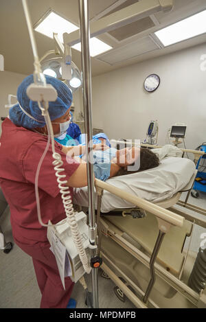 Nurse helping woman table dans la chirurgie de l'hôpital privé Banque D'Images