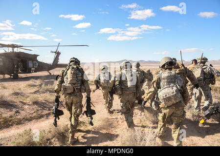 Des soldats américains avec le 11e Régiment de cavalerie blindée évacuer un soldat de jeu de rôle dans un UH-60 Black Hawk de la simulation d'une zone de combat après avoir sécurisé la zone d'atterrissage d'un hélicoptère pendant leur raid au cours d'assaut aérien National Training Centre 17-04 à Fort Irwin, en Californie, le 28 février 2017. Le but de cet exercice était de rétablir des communications stratégiques, qui sont décisives pour la mission du régiment de commandement pour les opérations militaires. (U.S. Photo de l'armée par Pvt. Austin) Anyzeski Banque D'Images