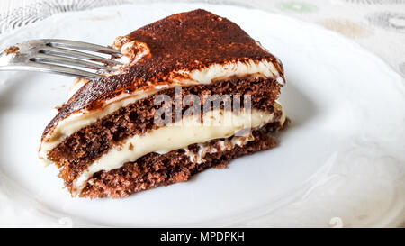 Gâteau tiramisu tranche avec la fourchette sur l'assiette blanche concept dessert. Banque D'Images