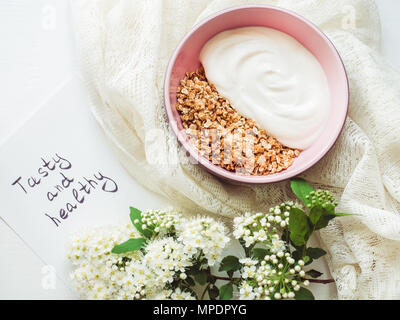 Les smoothies, muesli aux noix dans une belle assiette, serviette de table, bouquet de lilas en fleurs et d'ordinateurs portables avec une inscription sur un tableau blanc. Vue de dessus, le clos Banque D'Images