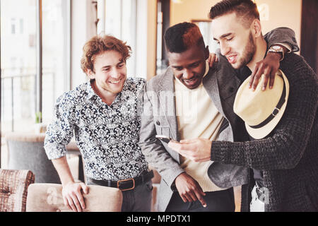 Cheerful vieux amis communiquer les uns avec les autres et du téléphone dans un pub. Notion de divertissement et de style de vie. Connexion Wi-Fi au réseau local connecté au bar de la table de concertation Banque D'Images