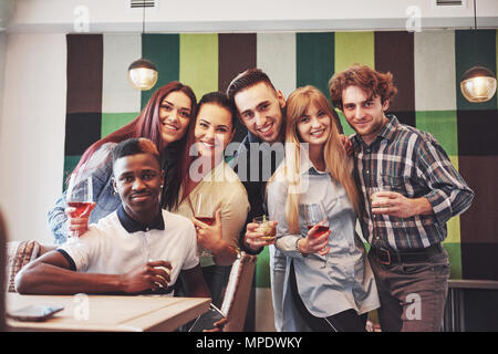 Les gens s'amuser à multiraciale en prenant un café avec selfies téléphone mobile. Groupe de jeunes amis assis au restaurant Banque D'Images