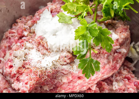 Born de viande hachée de bœuf et de porc en persillade avec sel poivre et oignons pour la cuisson des steaks frites saucisses barbecue Brochettes sur feu Foo Banque D'Images