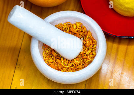 Mortier et pilon en marbre blanc avec le zeste d'orange séchée Banque D'Images