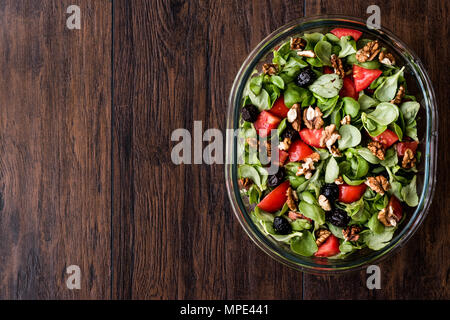 Le pourpier salade avec tomates, noix et d'olive sur la surface en bois. Concept d'aliments biologiques. Banque D'Images