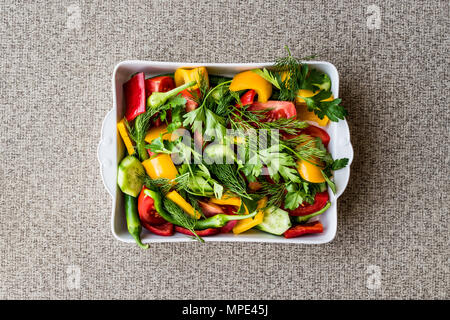 Avec de l'aneth, Salade de poivron jaune, poivron rouge, persil, tomate et concombre dans le bol blanc. Concept d'aliments biologiques. Banque D'Images