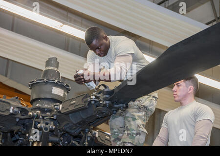 La CPS. Ainsworth L., Carridice et SPC. Jose Castaneda avec Société Delta 1er Bataillon, 3e Régiment d'aviation d'attaque (Reconnaissance) phase de conduite d'entretien sur un hélicoptère AH-64 Apache à Katterbach Army Airfield, Allemagne, le 10 février 2017. Les inspections de maintenance phase se produire à intervalles réguliers sur tous les aéronefs afin de les maintenir opérationnels. (U.S. Photo de l'armée de l'information visuelle par Moumoulidis Spécialiste Georgios, TSC Ansbach/relâché). Banque D'Images