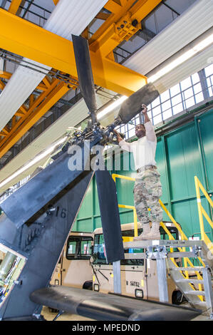 La CPS. Ainsworth L. Carridice avec Société Delta 1er Bataillon, 3e Régiment d'aviation d'attaque (Reconnaissance) procède à la phase de maintenance sur un hélicoptère AH-64 Apache à Katterbach Army Airfield, Allemagne, le 10 février 2017. Les inspections de maintenance phase se produire à intervalles réguliers sur tous les aéronefs afin de les maintenir opérationnels. (U.S. Photo de l'armée de l'information visuelle par Moumoulidis Spécialiste Georgios, TSC Ansbach/relâché). Banque D'Images