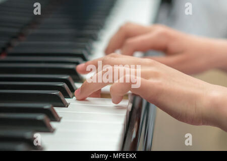 Les mains des enfants jouent du piano. La main de l'enfant sur les touches de piano. Banque D'Images