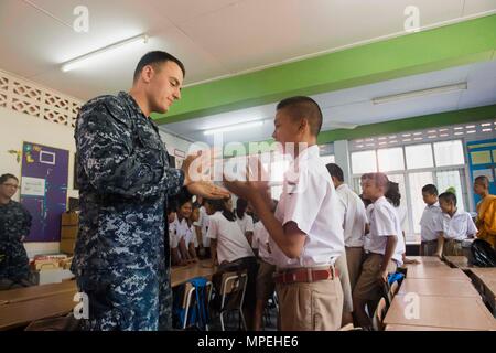 170214-N-GR361-115 RAYONG, Thaïlande (fév. 14, 2017) La Marine américaine technicien électronique 2e classe Kristopher Coiffure joue un jeu avec un étudiant au cours d'un échange culturel au Wat Samnak Thon Elementary School dans le cadre de l'exercice Gold Cobra 2017. Comme l'an dernier, 2017 Gold Cobra insiste sur la coordination sur l'action civique, tels que l'aide humanitaire et des secours en cas de catastrophe, de chercher à accroître la coopération régionale et la collaboration dans ces domaines essentiels. (U.S. Photo par marine Spécialiste de la communication de masse 2e classe Kaleb R. Staples/libérés) Banque D'Images