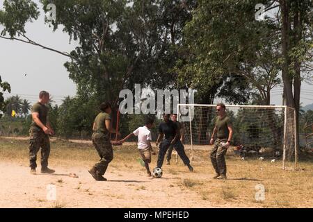 170214-N-GR361-159 RAYONG, Thaïlande (fév. 14, 2017) un marin américain et les Marines jouent au football avec les élèves au cours d'un échange culturel au Wat Samnak Thon Elementary School dans le cadre d'Or 2017 Cobra. Comme l'an dernier, 2017 Gold Cobra insiste sur la coordination sur l'action civique, tels que l'aide humanitaire et des secours en cas de catastrophe, de chercher à accroître la coopération régionale et la collaboration dans ces domaines essentiels. (U.S. Photo par marine Spécialiste de la communication de masse 2e classe Kaleb R. Staples/libérés) Banque D'Images