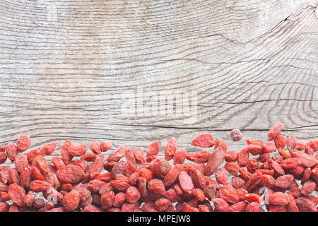 Les baies de Goji sur la surface en bois patiné, bois de chêne texture background copiez l'espace. Banque D'Images