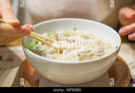 Woman eating classique vietnamienne soupe de nouilles. Banque D'Images