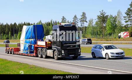 Volvo FH 540 noir semi-remorque transporte objet industriel comme charge surdimensionnée parmi la circulation sur autoroute sur une journée ensoleillée de l'été à Salo, Finlande - le 18 mai 20 Banque D'Images