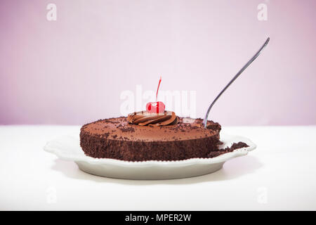 Gâteau au chocolat avec cerise sur le dessus et il se bloque dans la fourche Banque D'Images