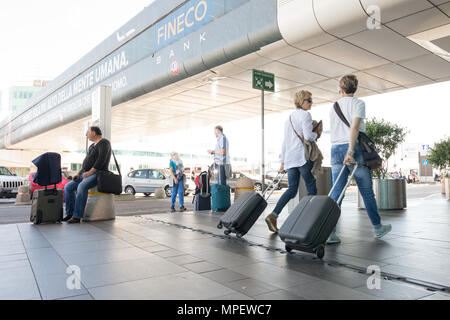 L'aéroport Rome Fiumicino, les passagers avec chariot de marche et suitcase Banque D'Images