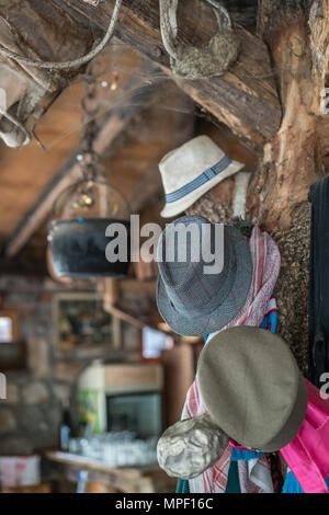 Gros plan détail de quelques vieux chapeaux pendu à une poutre dans un ancien hangar agricole transformé restaurant Banque D'Images